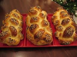Three braided challah breads on a red platter.