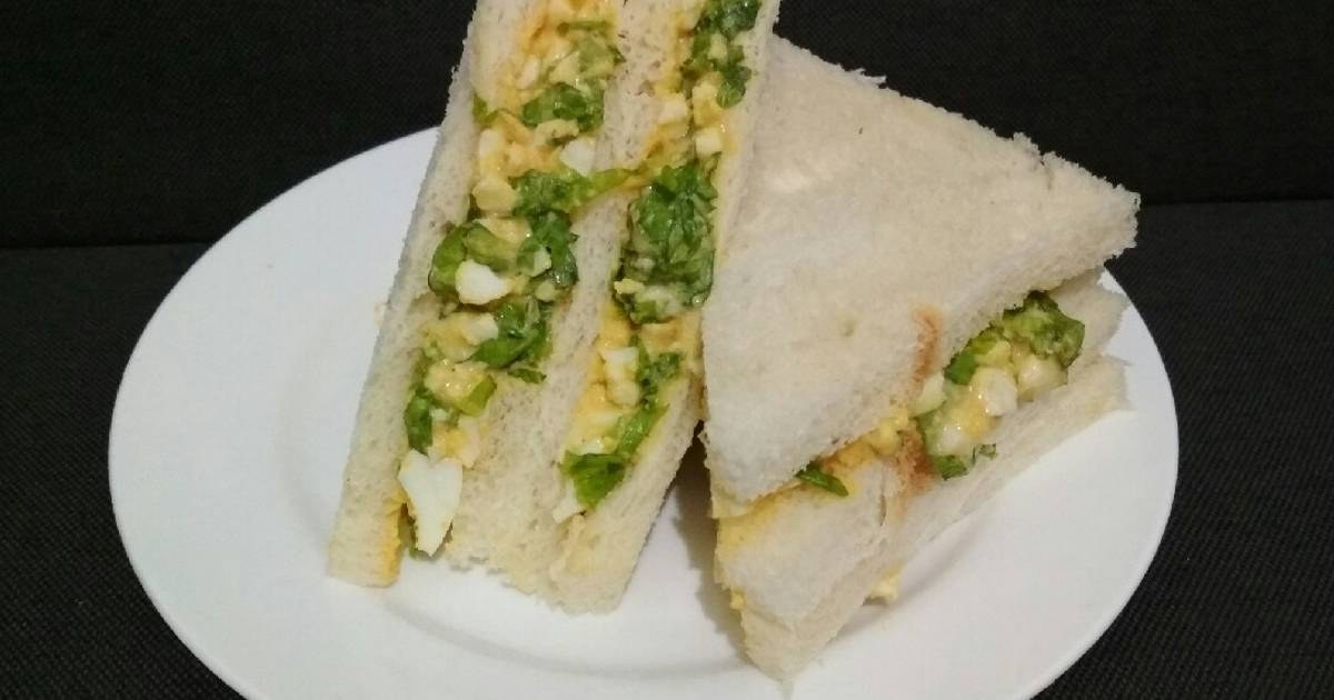 Egg salad sandwiches with lettuce on white bread.