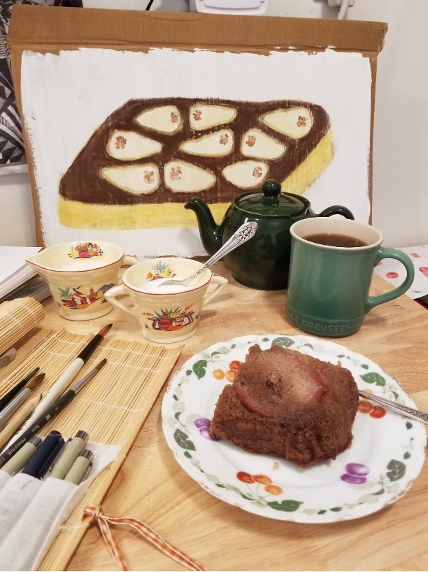 Cozy tea time with chocolate cake and a colorful painting in the background.
