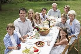 Family enjoying an outdoor meal together on a sunny day.