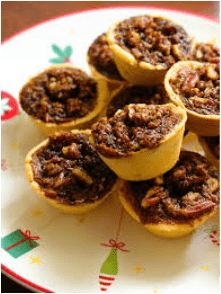 Mini pecan pies arranged on a festive plate.