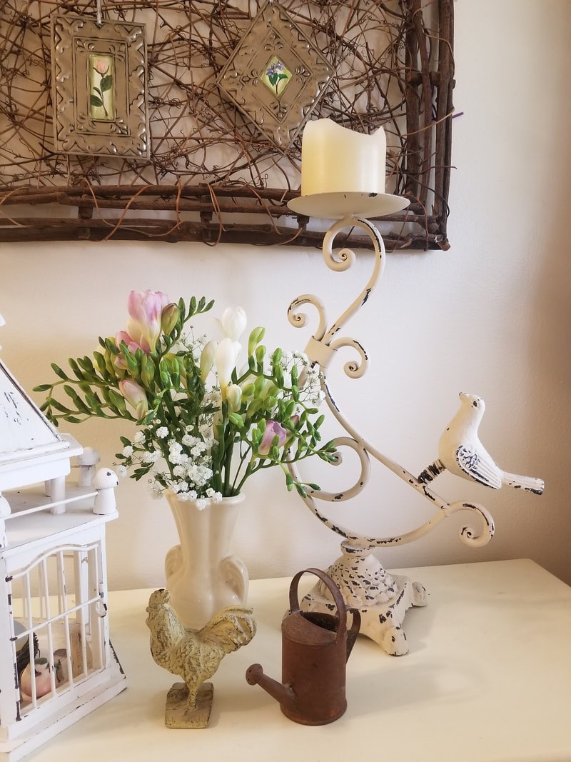 Elegant vintage decor with flowers, a candle, and a bird sculpture.