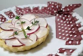 A tart topped with radish slices and thyme sprigs.