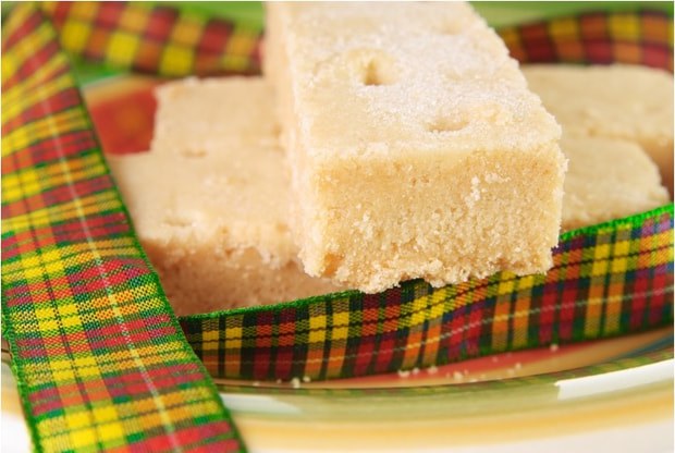 Close-up of two pieces of moist white cake on a plate with colorful cloth.