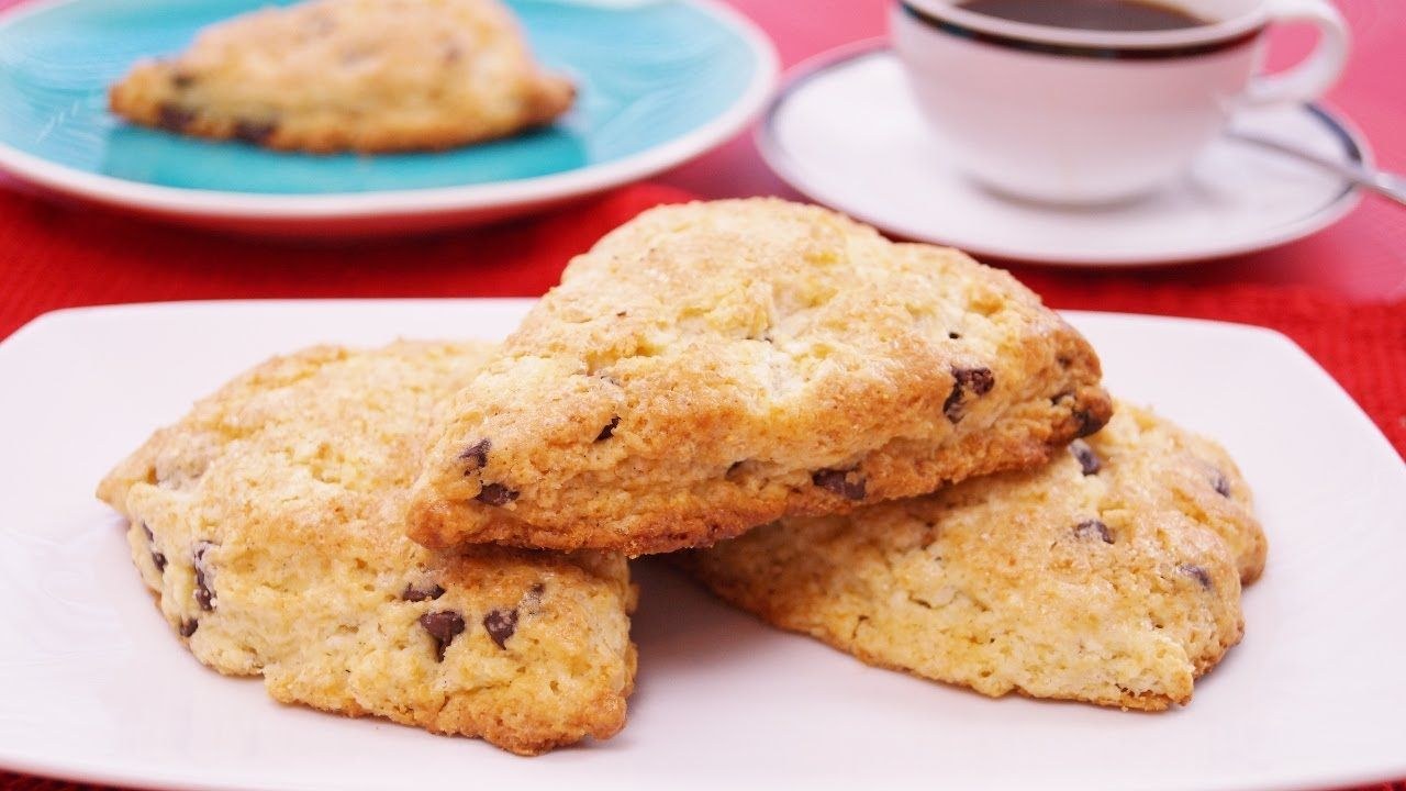 Close-up of two scone halves on a plate with a cup in the background.