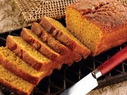 Slices of golden brown pumpkin bread on a cooling rack.