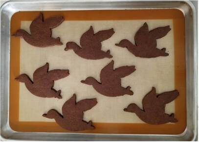 Chocolate bird-shaped cookies on a tray.