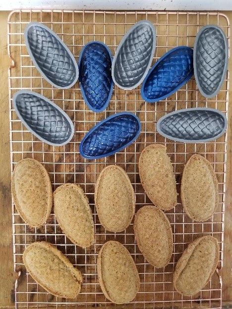 Various oval-shaped loaves of bread cooling on racks.
