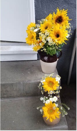 A bouquet of bright yellow flowers on concrete steps.