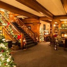 Cozy Christmas-decorated lobby with wooden stairs and warm lighting.