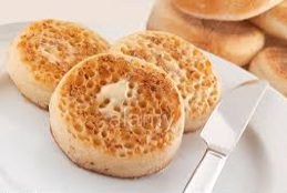 Two toasted English muffins with butter on a plate.