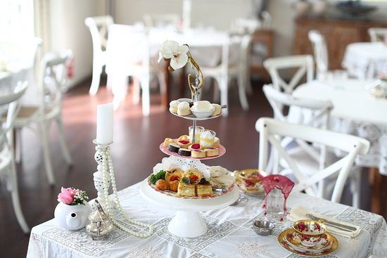 Elegant tea party setup with tiered tray and floral decor.