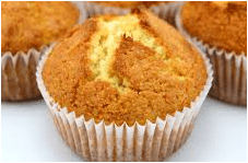 A close-up of a golden, freshly baked muffin in a white paper liner.