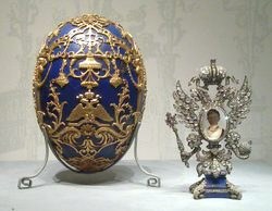 Ornate Fabergé egg and elaborate silver clock displayed together.