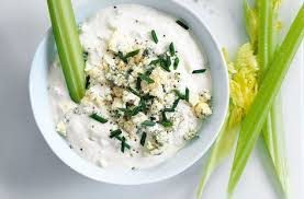 Creamy dip with herbs and celery sticks on the side.