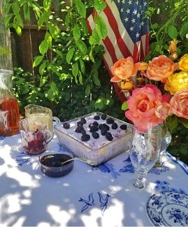 Outdoor table with dessert and flowers.