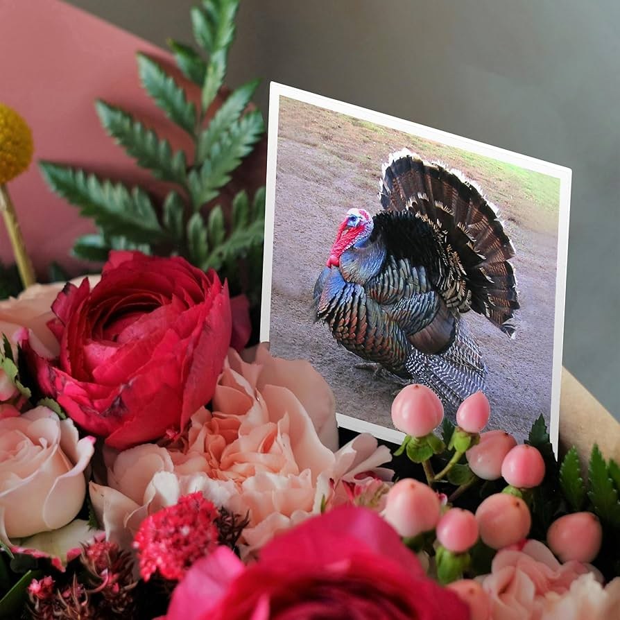 A festive turkey decoration among vibrant flowers and greenery.