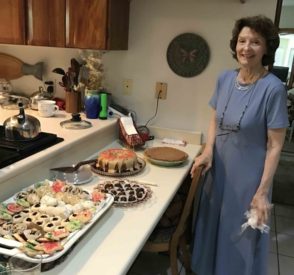 Woman standing by table with desserts.