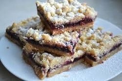 Three crumb-topped fruit bars stacked on a plate.