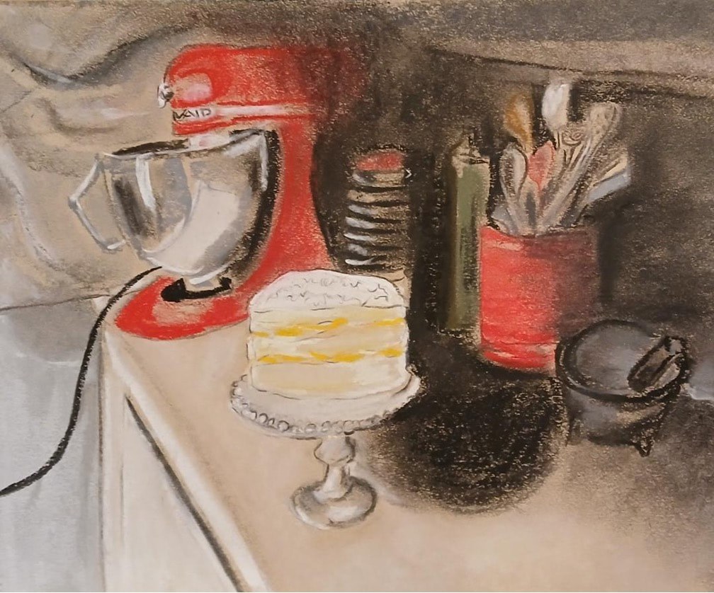 A stand mixer and cake on a kitchen counter.