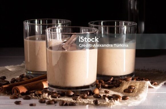 Three glasses of creamy chocolate mousse with chocolate shavings.