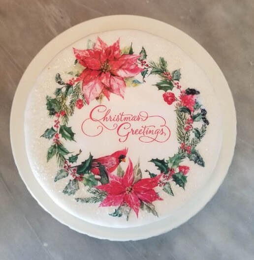 Festive cake decorated with poinsettias and Christmas greetings.