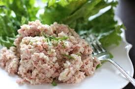 A close-up of creamy tuna salad with lettuce and a fork.