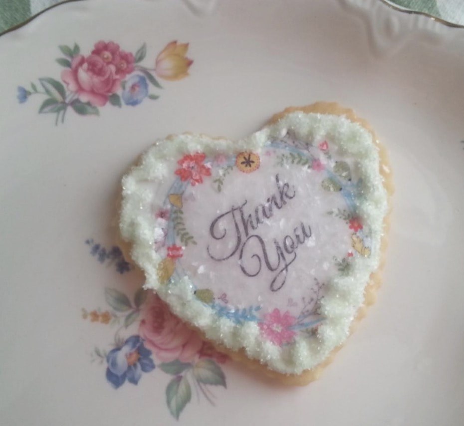 Heart-shaped cookie with 'Thank You' icing decoration.