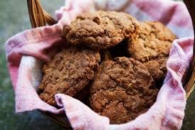 Basket of freshly baked oatmeal cookies on a pink cloth.