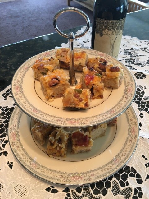 Two-tier plate stand with homemade fruitcake slices and a cup of tea.