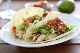 Two tacos filled with grilled chicken, lettuce, and salsa.