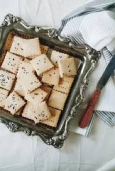 A tray of square crackers sprinkled with seeds.