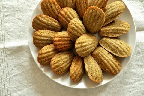 Plate of golden madeleine cookies arranged neatly.