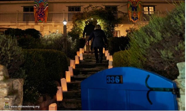 A person climbs stairs illuminated by candle-lit bags at night.