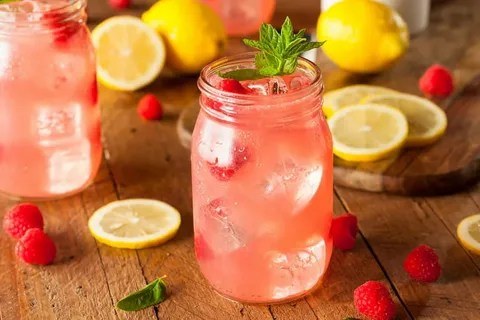 Refreshing pink lemonade in a mason jar with ice and mint.