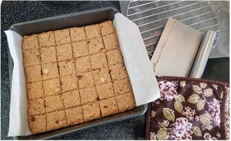 Freshly baked blondies cut into squares on parchment paper.
