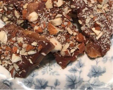 Close-up of almond chocolate bark on a floral plate.
