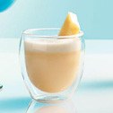A creamy beverage with a lemon twist in a double-walled glass.