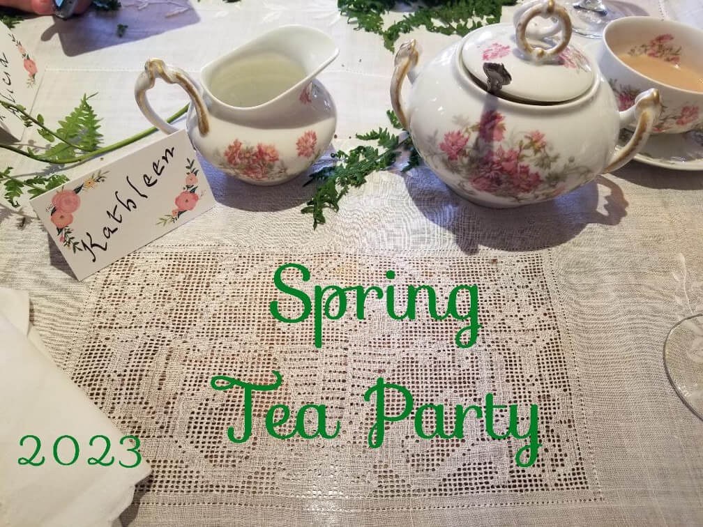 Elegant spring tea party setup with floral teapot and cup.