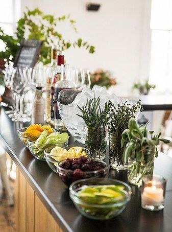 A table set with wine, glasses, and fresh herbs in a bright room.