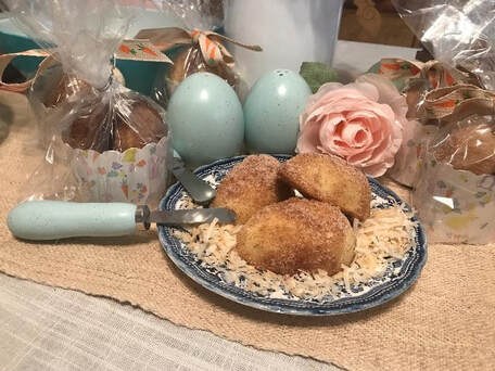 Plate of breaded croquettes on rice with decorative eggs and a flower.