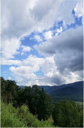 A scenic mountain landscape under a partly cloudy sky.