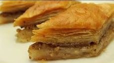 Close-up of a layered pastry dessert with a nut filling.