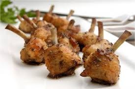 Close-up of seasoned grilled chicken drumsticks on a skewer.