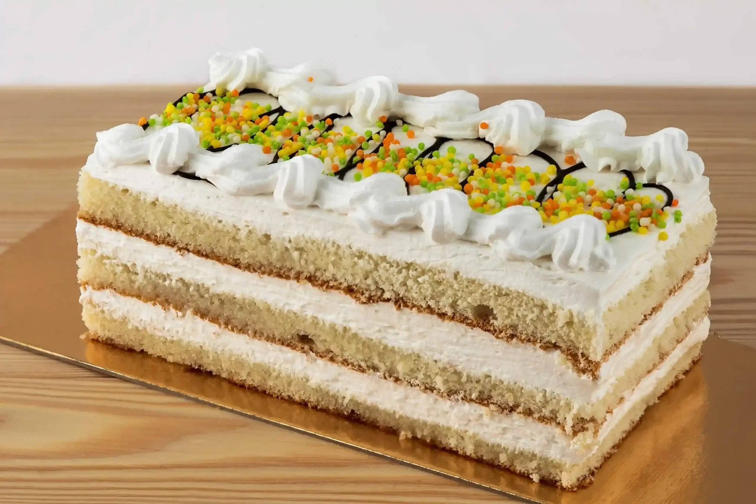 A layered cake with cream and pistachio topping.