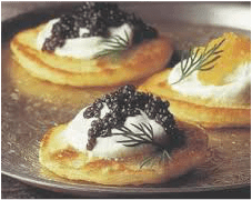 Elegant blinis topped with sour cream, dill, and black caviar.