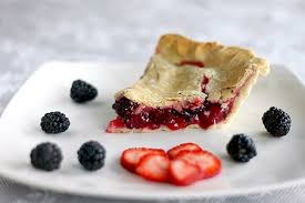 A slice of berry pie with fresh blackberries and strawberries.
