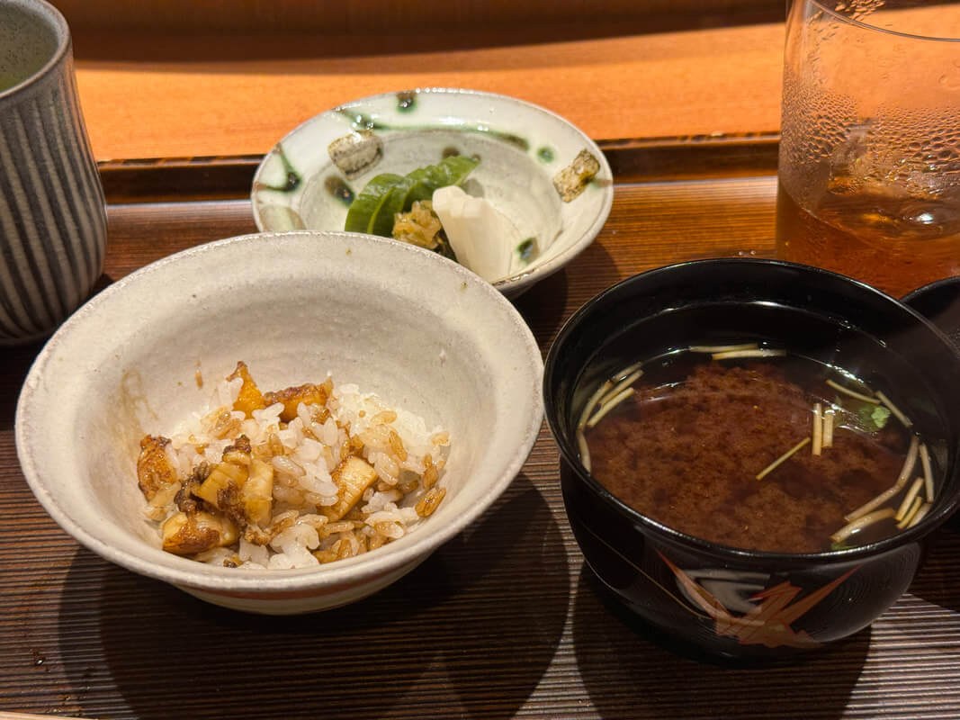 A simple Japanese meal with rice, miso soup, and pickled vegetables.