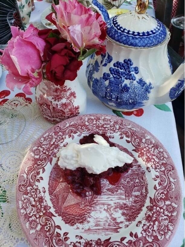 Tea set with dessert and flowers.