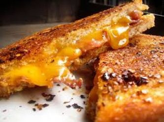 Close-up of a crispy grilled cheese sandwich with melted cheddar.